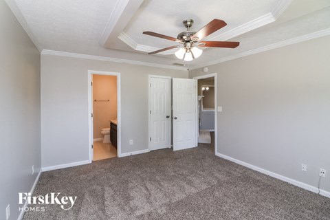 a living room with carpet and a ceiling fan