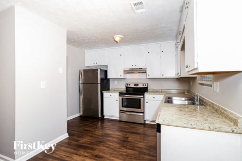 a kitchen with white cabinets and stainless steel appliances
