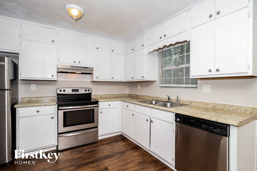 a kitchen with white cabinets and stainless steel appliances