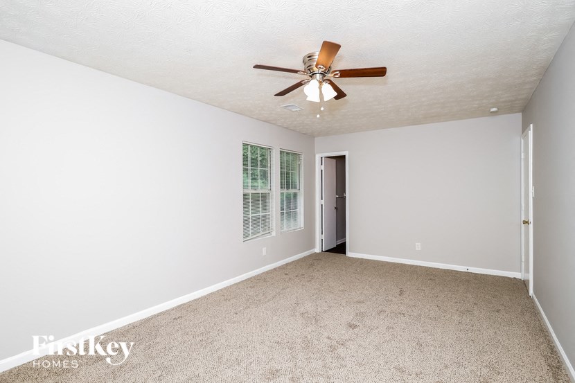 a empty living room with a ceiling fan