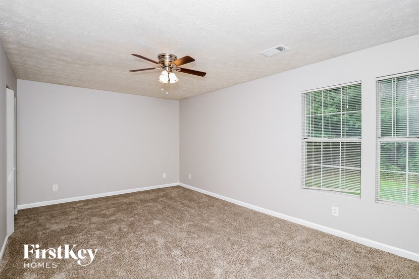 a living room with a ceiling fan and a window