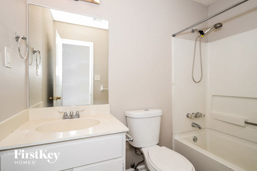 a white bathroom with a sink toilet and a shower
