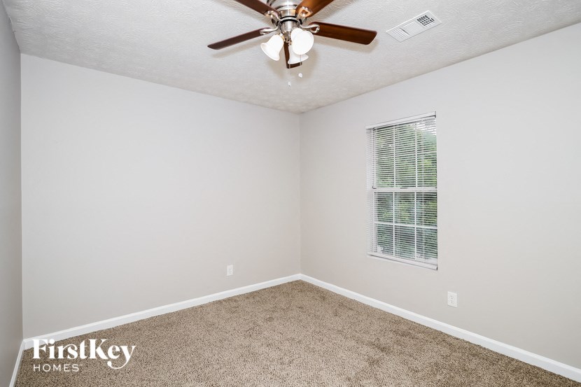 a bedroom with a ceiling fan and a window