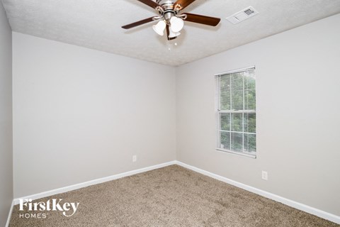 a bedroom with a ceiling fan and a window