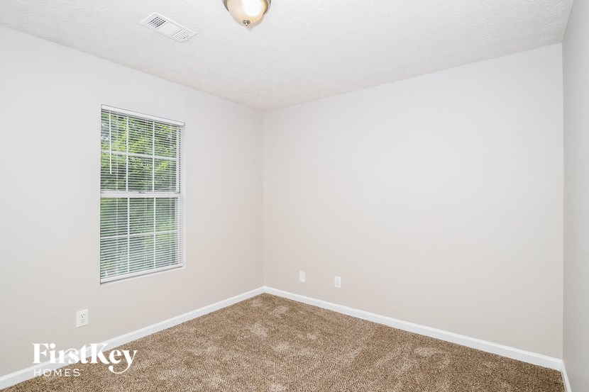 an empty room with a window and a carpet
