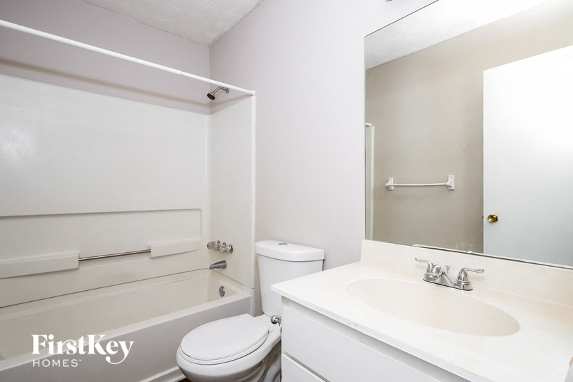 a white bathroom with a sink toilet and bath tub