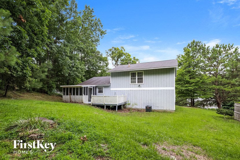 a small white house with a porch and a grassy yard