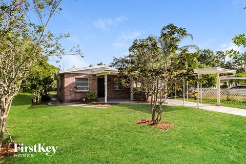 A house with a lawn and trees in front of it.