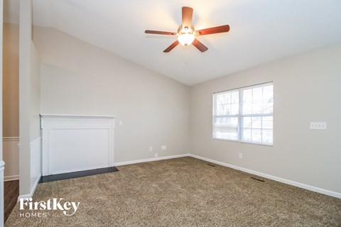 A room with a ceiling fan and a window.