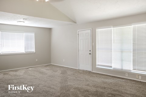 a bedroom with a carpeted floor and a white door and window