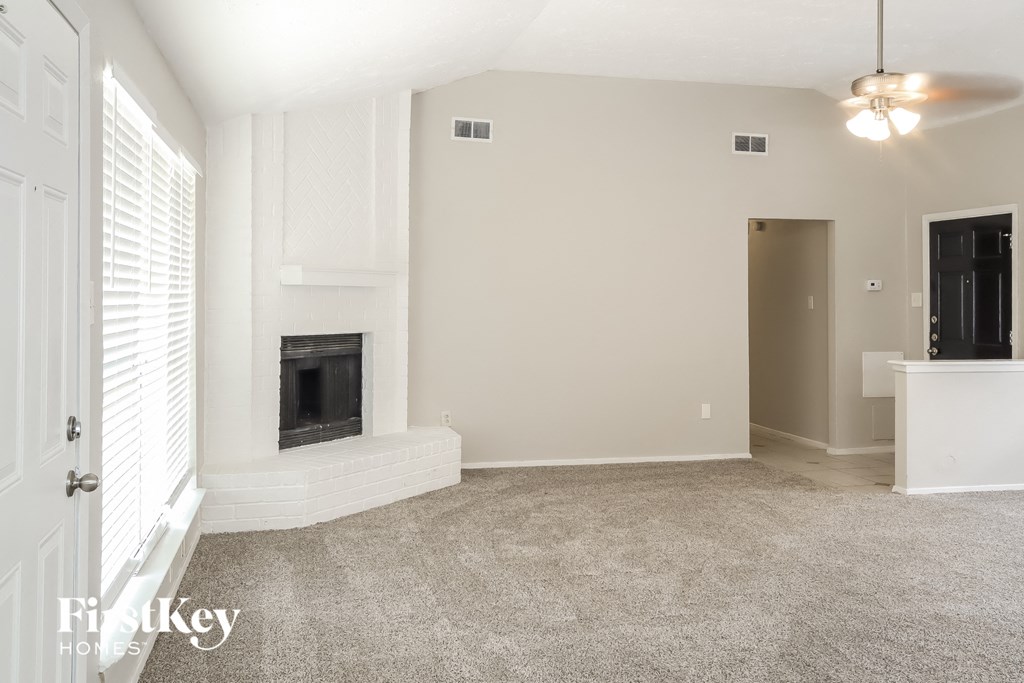a living room with a fireplace and a carpeted floor
