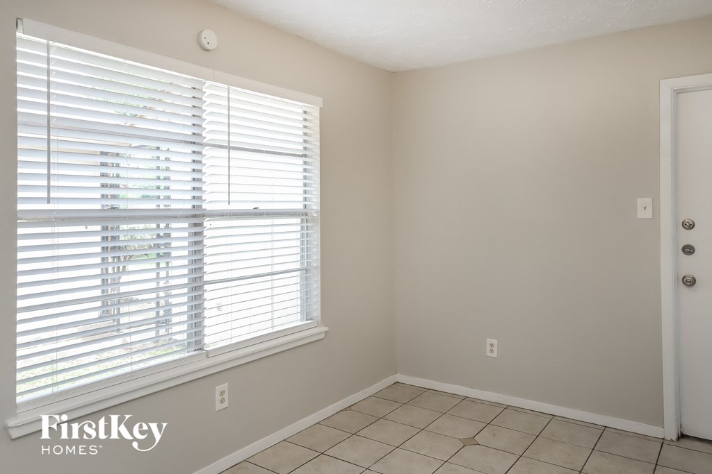 a bedroom with a large window and a tiled floor