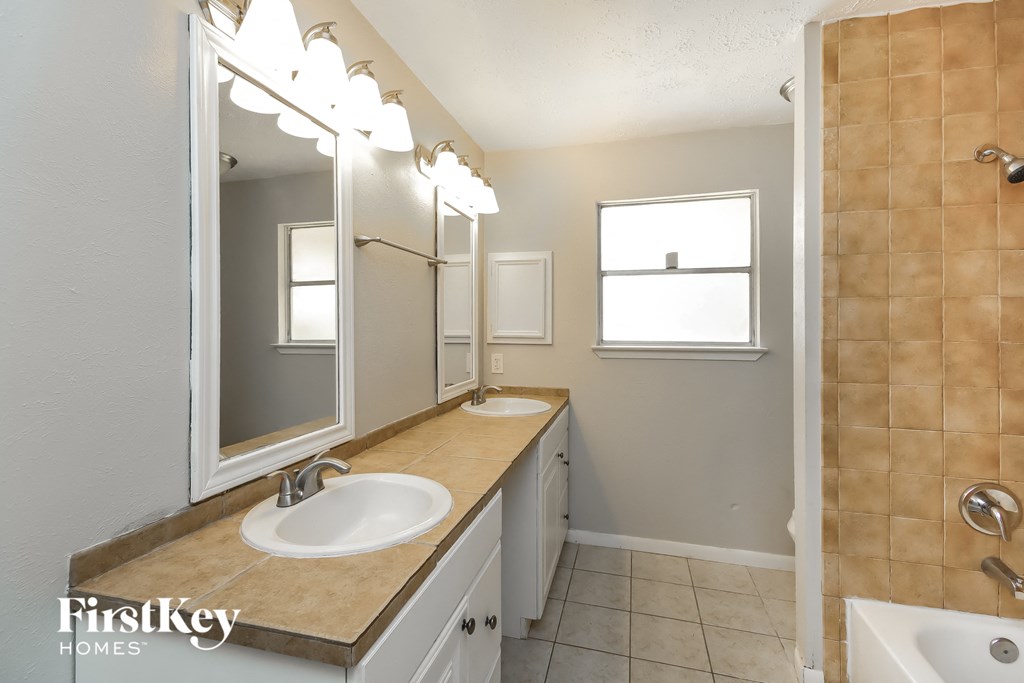 a bathroom with two sinks and a large mirror