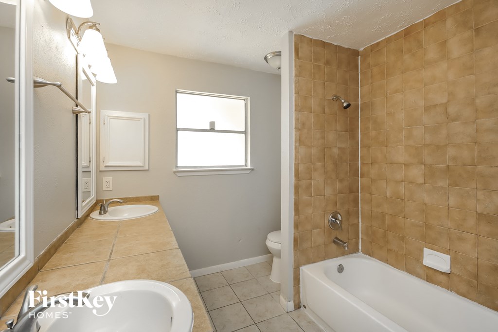 a bathroom with a tub and a sink and a shower