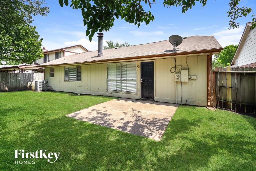 a backyard with a white house and a yard and a satellite dish