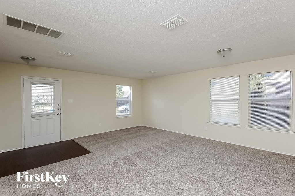 the living room of a home with a carpeted floor and a white door
