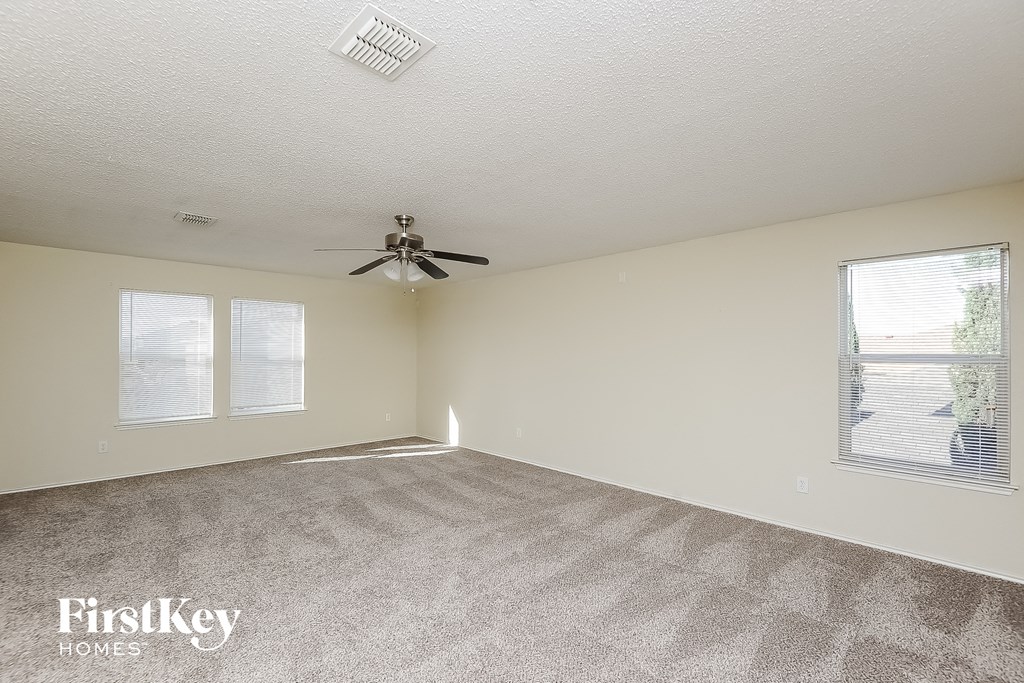 a living room with carpet and a ceiling fan