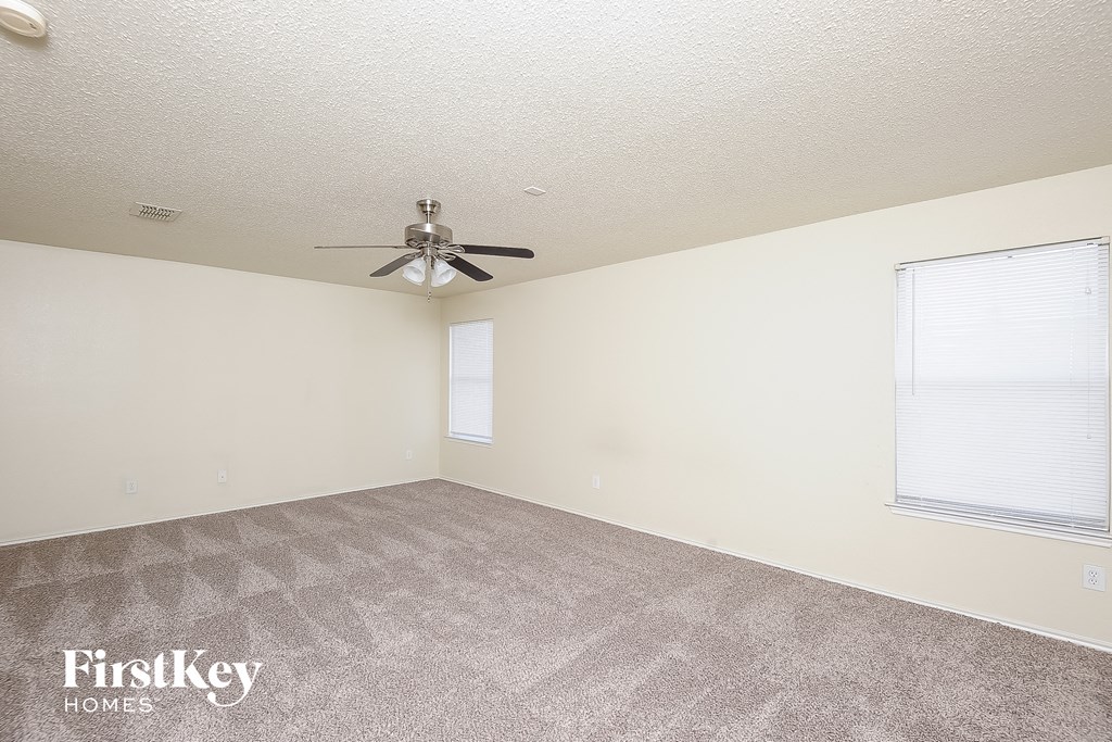 a living room with carpet and a ceiling fan