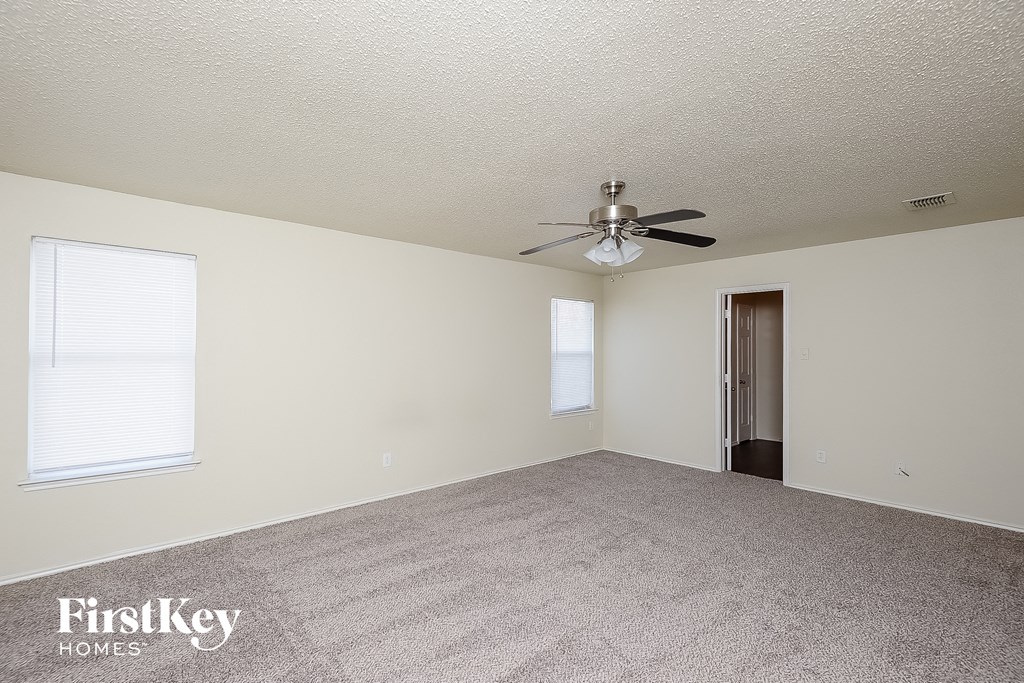 the living room of an empty house with a ceiling fan