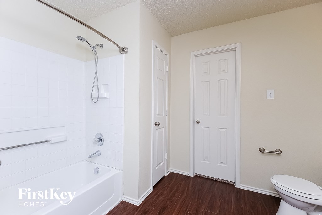 a bathroom with a toilet and a tub and a shower