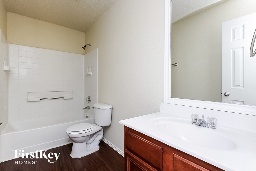 a bathroom with a toilet and a sink and a mirror