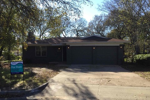 the front of a house with a driveway and a garage door