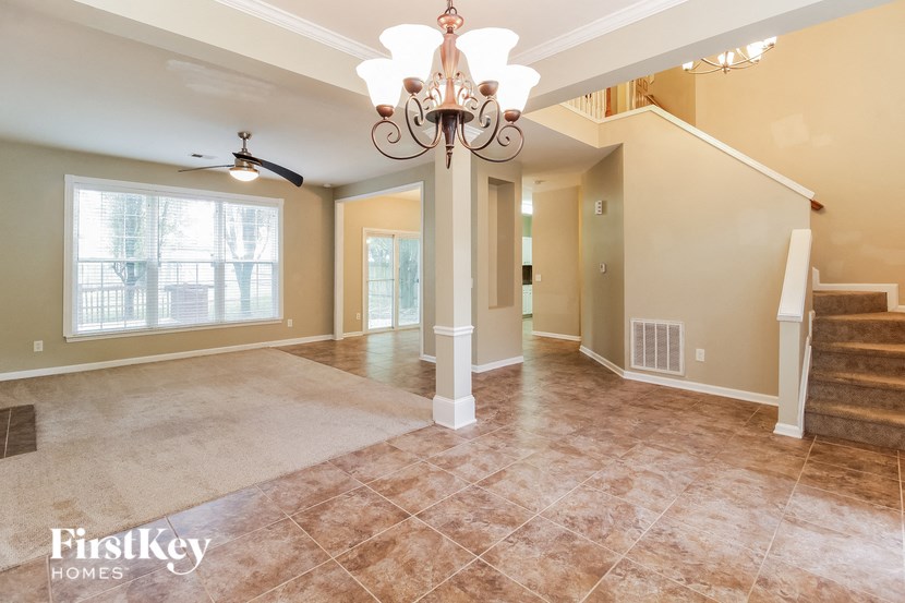 the living room of an empty home with a chandelier
