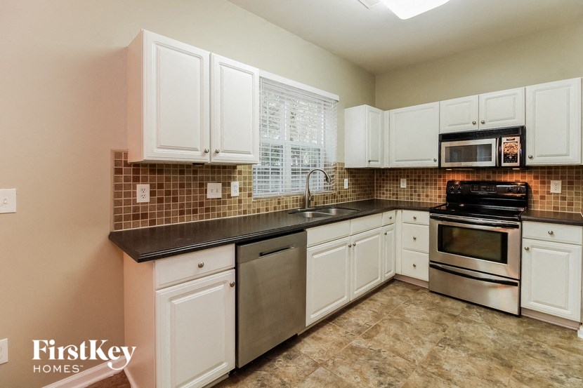 a kitchen with white cabinets and stainless steel appliances