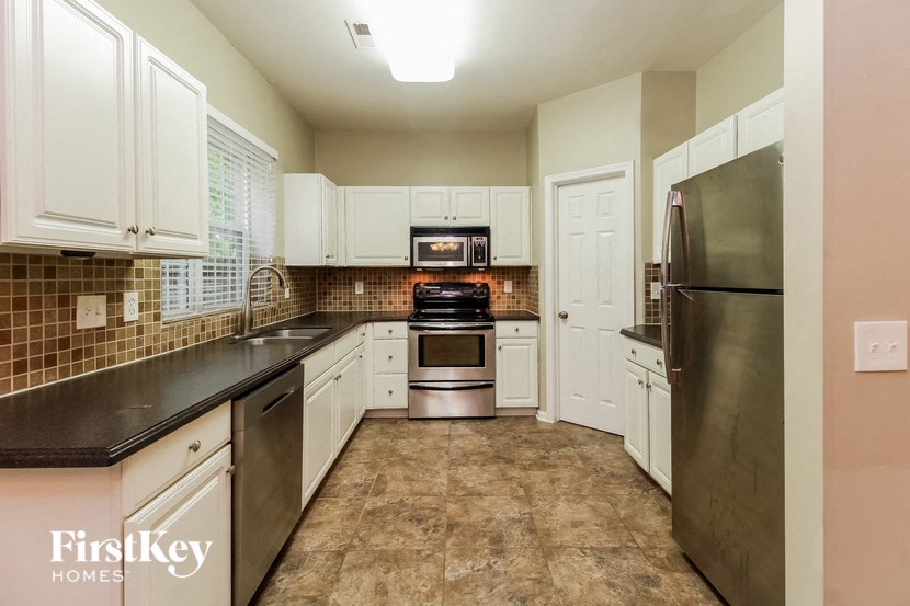 a kitchen with white cabinets and stainless steel appliances