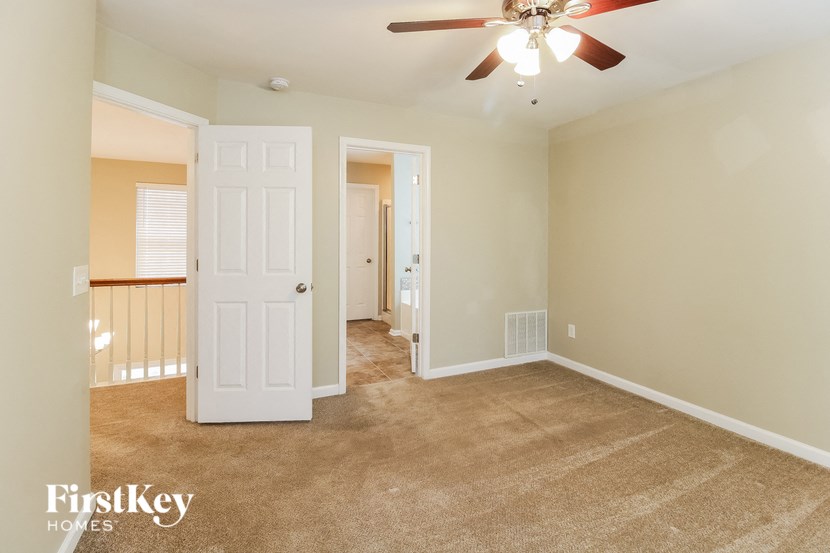 a living room with carpet and a ceiling fan