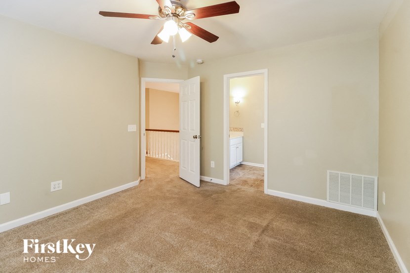 a living room with carpet and a ceiling fan