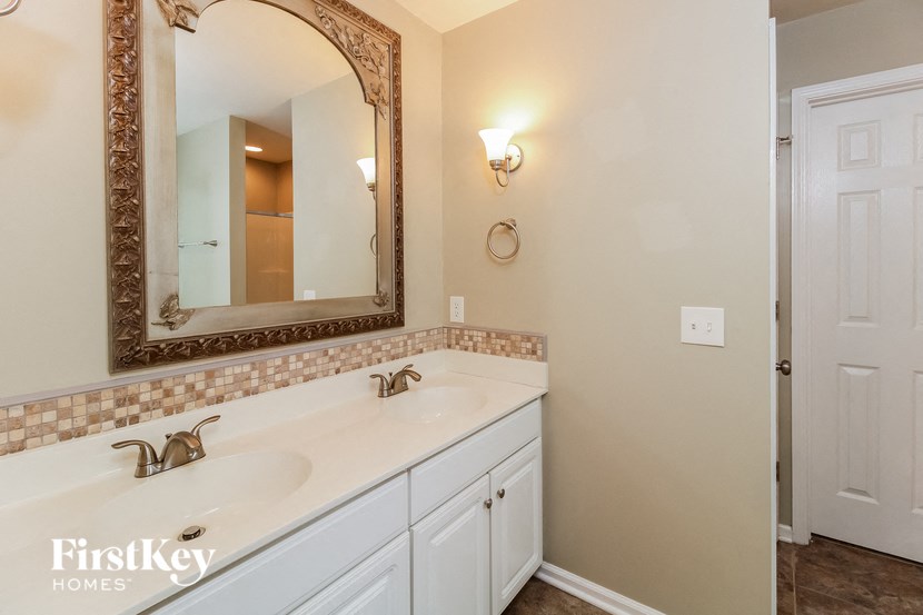 a bathroom with a sink and a mirror and a door