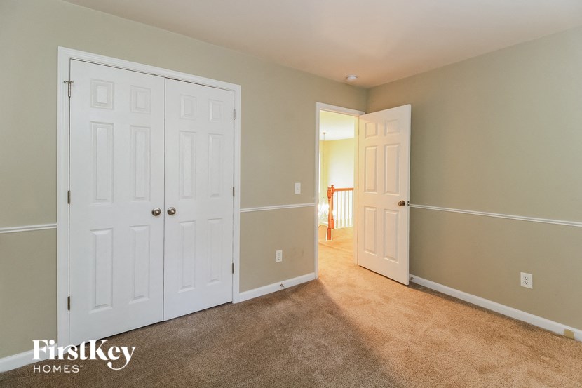 a bedroom with two closets and two doors and a carpeted floor