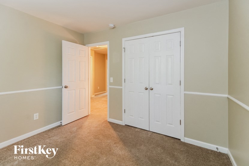 a bedroom with two closets and a hallway with two doors