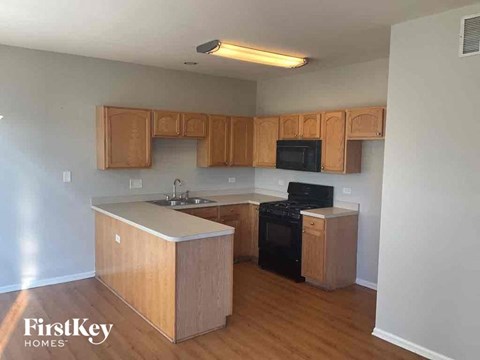 an empty kitchen with wood flooring and wooden cabinets