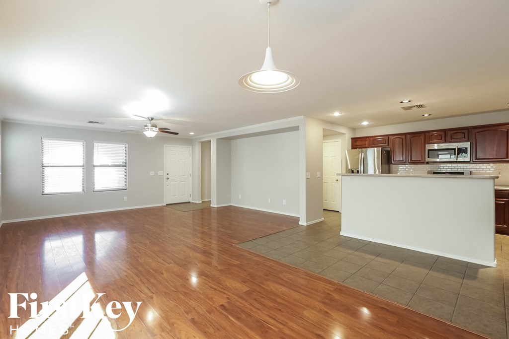 A spacious living room with a kitchen in the background.