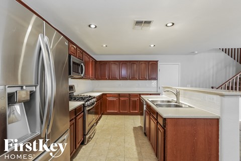 A kitchen with brown cabinets and a stainless steel refrigerator.