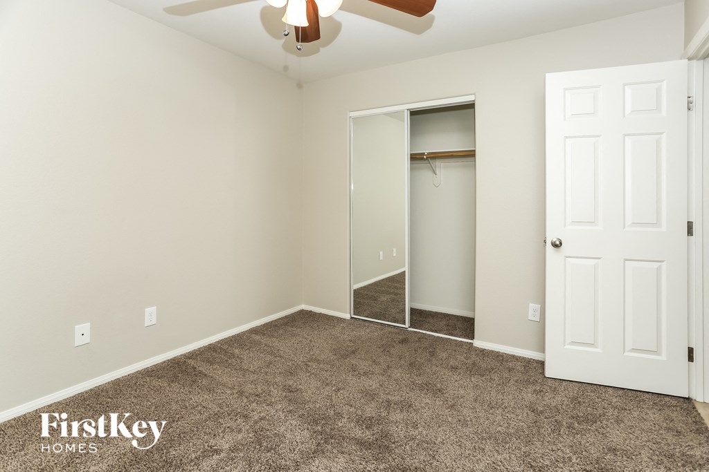 a bedroom with a carpeted floor and a closet