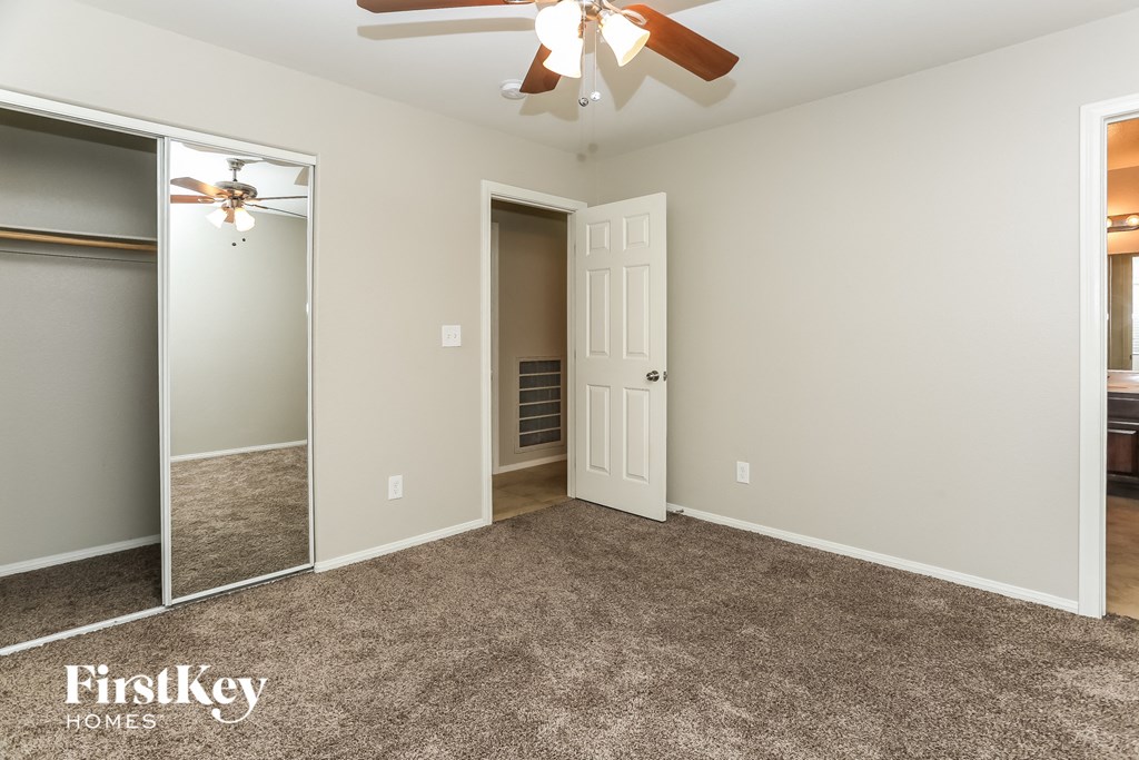 a bedroom with a carpeted floor and a ceiling fan