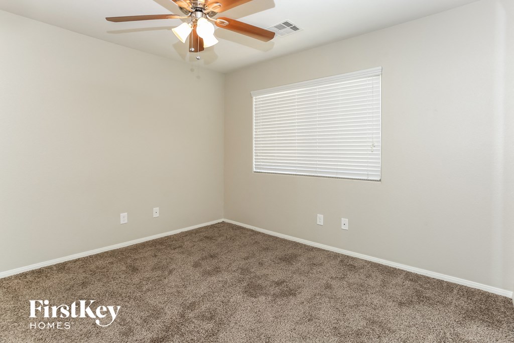 a bedroom with carpet and a ceiling fan
