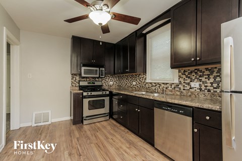 a kitchen with dark wood cabinets and stainless steel appliances
