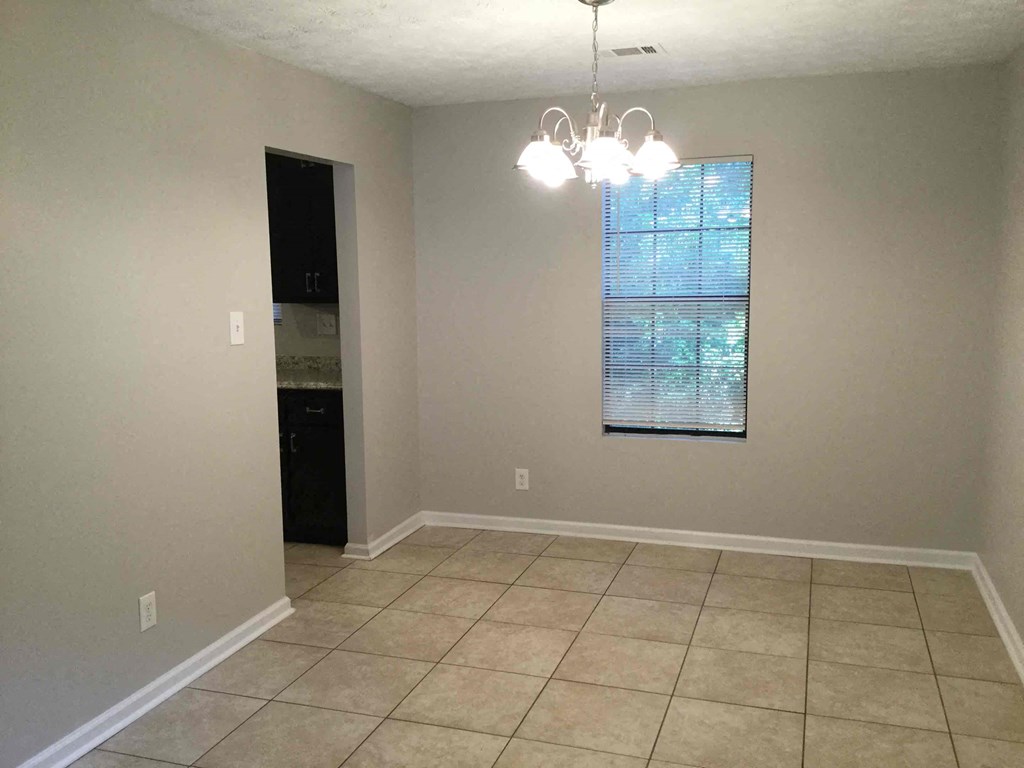 A room with a window and a chandelier.