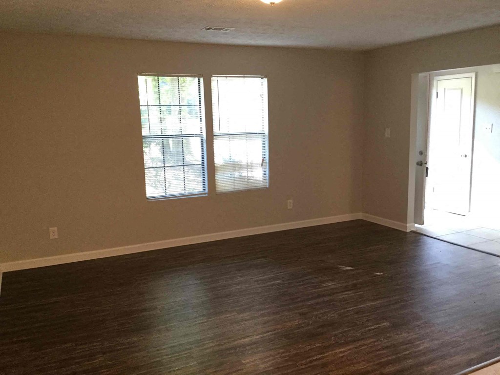 Empty room with wooden floors and a window.