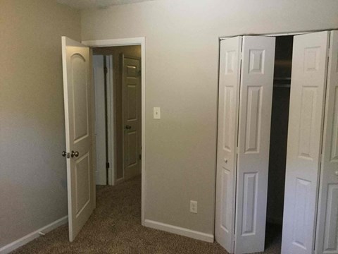 A hallway with two doors open and one closed.