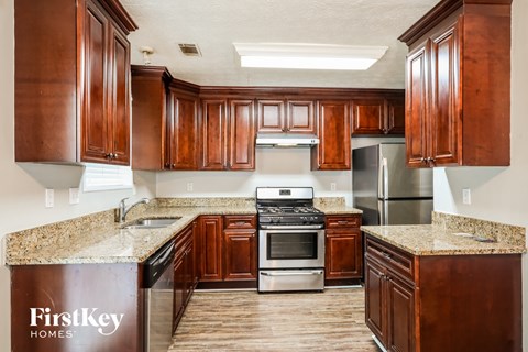 a kitchen with wood cabinets and granite counter tops and stainless steel appliances