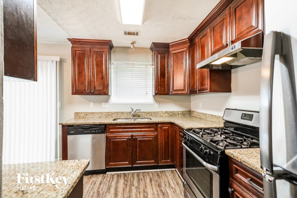 a kitchen with wooden cabinets and stainless steel appliances