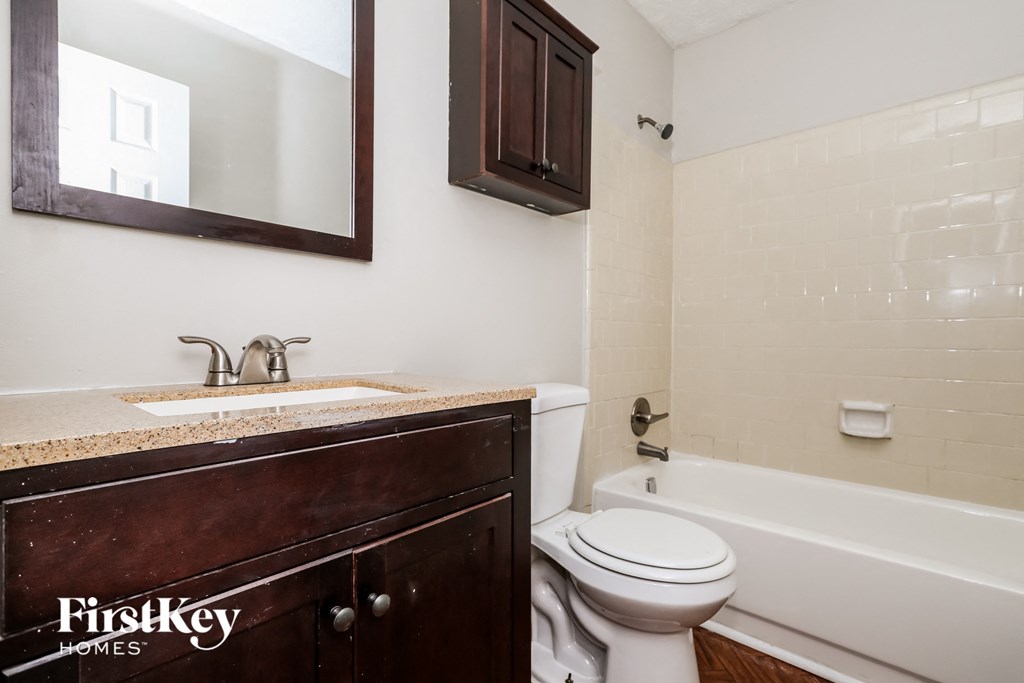a bathroom with a toilet and a sink and a bath tub