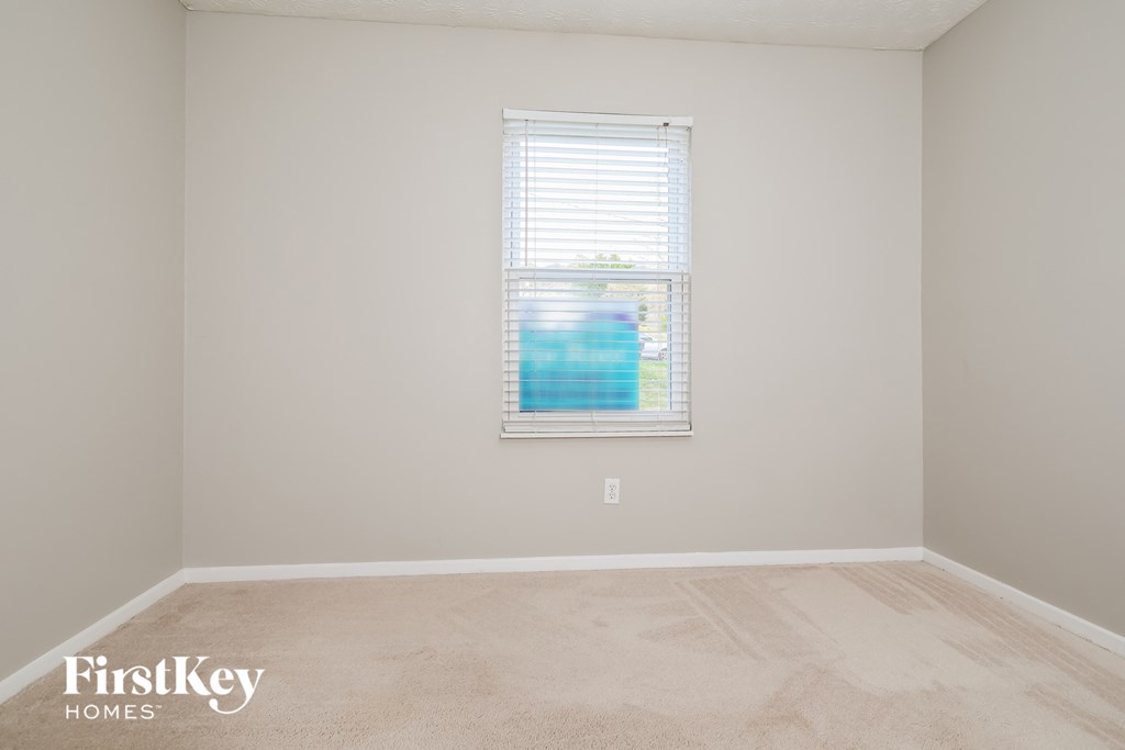 a empty room with a window and a carpeted floor