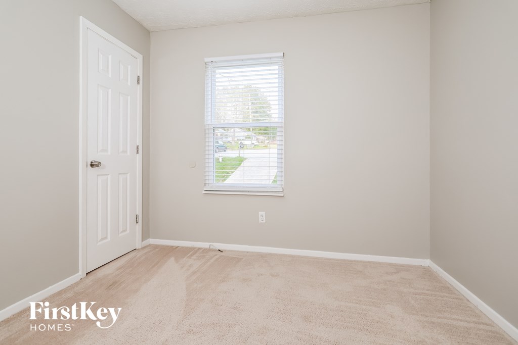 a bedroom with a white door and a window