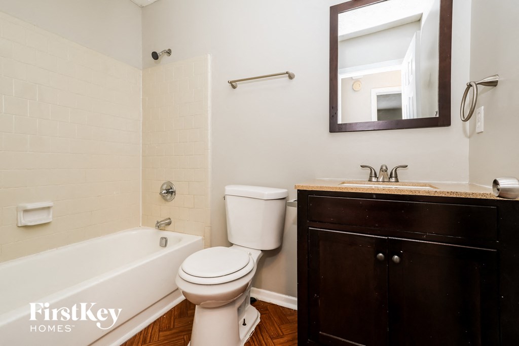 a bathroom with a toilet sink and tub and a mirror